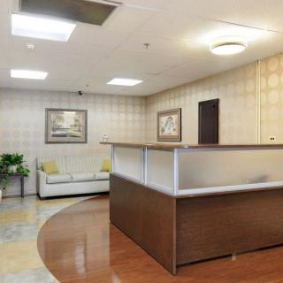 Modern office reception area with a central desk and seating.