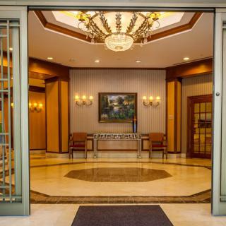 Elegant lobby interior with a chandelier and artwork on display.