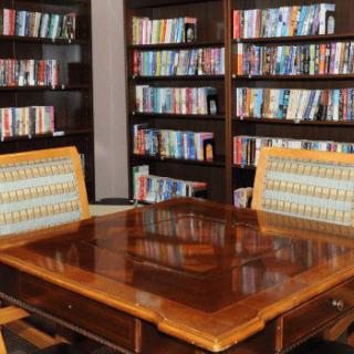 A cozy library space with wooden tables and bookshelves filled with books.