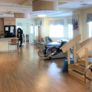 A spacious rehabilitation center equipped with exercise machines and therapy stairs.