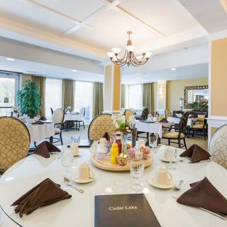 A beautifully set table in an elegant dining room with a chandelier.