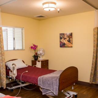 A well-lit hospital room with a bed and medical equipment.