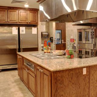 A modern kitchen featuring stainless steel appliances and a central island with wooden cabinets.