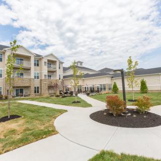 A modern apartment complex with well-maintained landscaping and paved pathways.