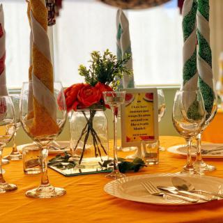A beautifully arranged table with colorful napkins, elegant glassware, and a floral centerpiece.
