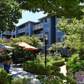 A peaceful apartment complex with a well-maintained garden and outdoor seating areas.