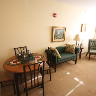 A cozy living room with a small dining table and classic furniture.