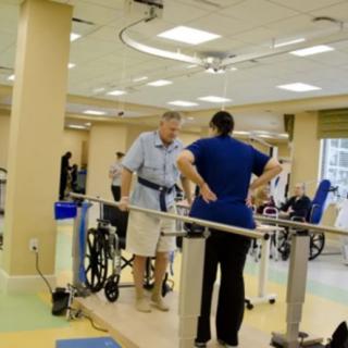 A patient undergoes physical therapy with the assistance of a healthcare professional in a rehabilitation center.