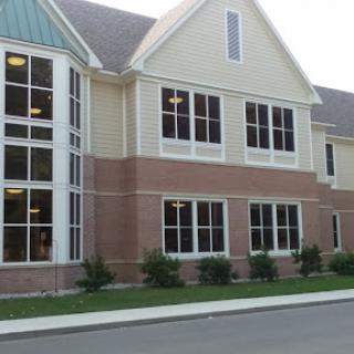 A modern building featuring a combination of brick and siding, with large windows that enhance natural light.