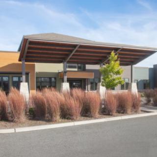 A modern commercial building with landscaped entrance and contemporary architectural design.
