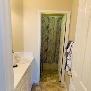Compact bathroom with a sink and shower area.