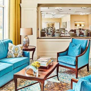 A cozy living room with blue seating and elegant decor.