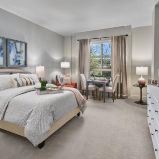A well-designed modern bedroom with a comfortable bed, stylish furniture, and warm lighting.