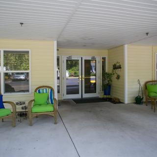 A building entrance with outdoor seating and decorative plants.