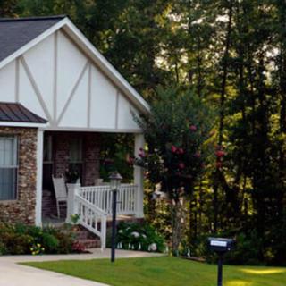 A charming house with a cozy porch surrounded by trees.