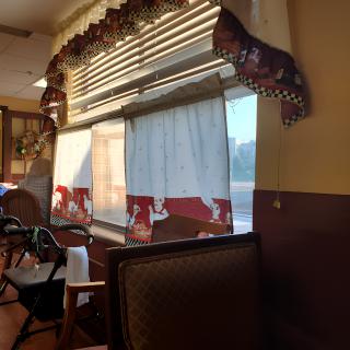 A cozy restaurant interior with decorative curtains and seating.