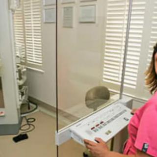 A nurse operating medical equipment in a hospital setting.