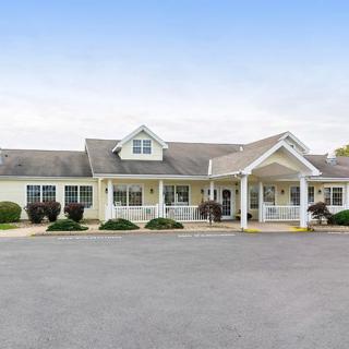 A suburban residential building with a porch and driveway.