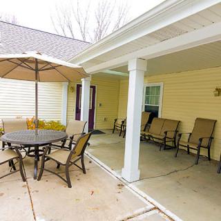 A cozy outdoor patio with seating and an umbrella, perfect for relaxation.