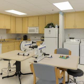 A well-equipped medical office featuring workstations with microscopes and a kitchenette area.
