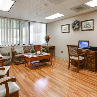 A cozy office waiting room with comfortable seating and a computer desk.