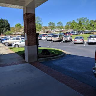A view of a busy parking lot on a sunny day, framed by the entrance of a building.