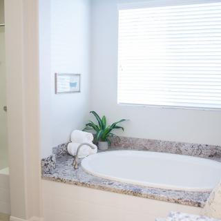 A modern, bright bathroom with a large bathtub and minimalist decor.