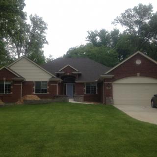 A suburban house with a brick exterior and well-maintained lawn.