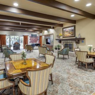 A spacious and elegantly decorated seating area with a fireplace and comfortable furniture.