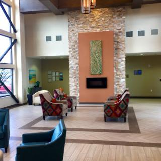 A modern and inviting lobby space featuring comfortable seating, a stylish fireplace, and natural lighting.