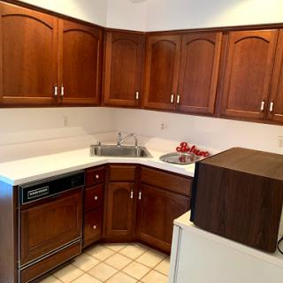 A cozy kitchen featuring wooden cabinets and a white countertop.