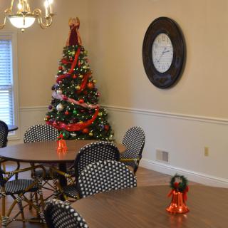 A cozy dining area decorated for Christmas with a festive tree and holiday ornaments.
