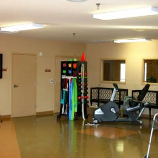 A well-equipped indoor fitness room with exercise machines and colorful workout gear.