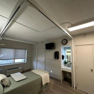 A cozy and modern room featuring a bed, a television, and an en-suite bathroom.