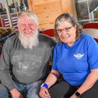 A cheerful couple sitting together indoors, both sharing a smile.