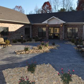 A brick building with a landscaped garden and pathway in the foreground.