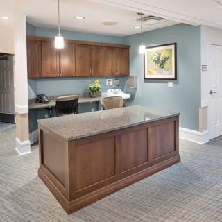 A modern reception area featuring a wooden desk and tasteful decor.
