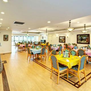 A spacious dining area with colorful table settings and bright lighting.