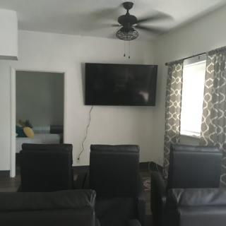A cozy living room setup with a wall-mounted television and comfortable seating.