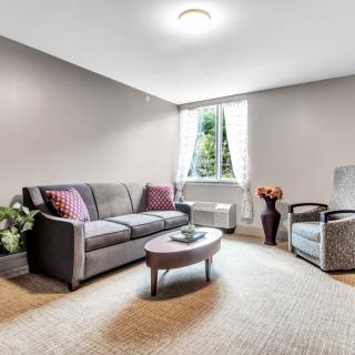 A modern living room with a comfortable sofa and armchair, centered around a coffee table, featuring neutral tones and natural light.
