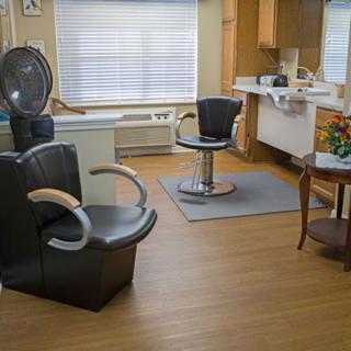 An empty hair salon with styling chairs, mirrors, and a warm interior.