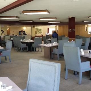 A spacious, modern restaurant interior with neatly arranged tables and chairs.