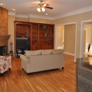 A cozy living room with wooden floors, a sofa, and a television.