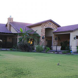 A beautiful residential house with a spacious lawn and stone accents.