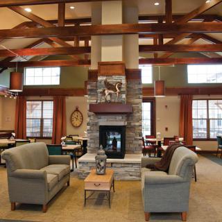 A cozy living room interior featuring a stone fireplace and comfortable seating.