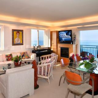 A modern living room with a stunning sea view, stylish furniture, and vibrant artwork.