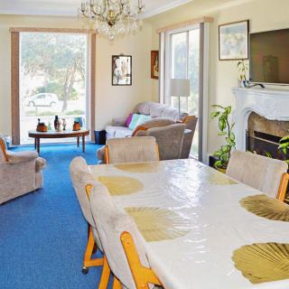 A spacious living room with a dining table, cozy seating, and a fireplace.