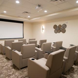 A cozy home theater setup featuring comfortable recliners and a large screen for movie nights.