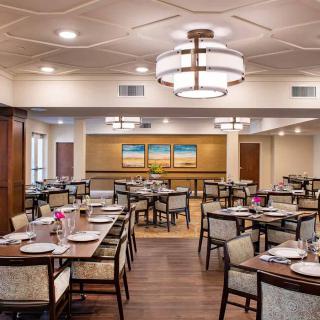A modern dining room with neatly arranged tables and elegant lighting.