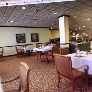 An empty restaurant dining area with neatly arranged tables and chairs.